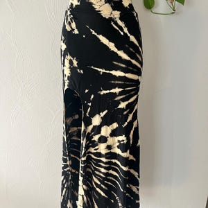 Colorful tie dye long high-waisted skirt for women with thigh slit, stretchy fabric, and boho festival style. Comfortable hippie summer skirt for casual wear, concerts, and vacation outfits.
