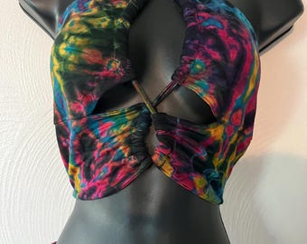 May include: A tie-dye halter top with a criss-cross design and a cutout in the front. The top is made of a soft, stretchy fabric and has a vibrant color scheme.