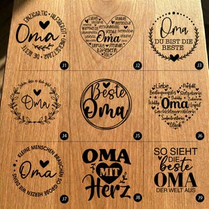 Puede incluir: Una superficie de madera muestra nueve placas decorativas con la palabra "Oma" (Abuela en alem&aacute;n) en varias fuentes y dise&ntilde;os. Las placas presentan corazones, detalles florales y frases como "Mejor abuela".