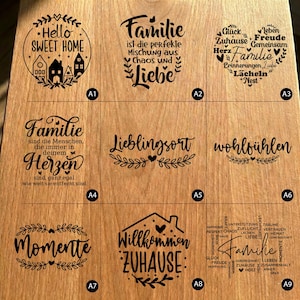 Puede incluir: Una superficie de madera con nueve dise&ntilde;os de texto negro diferentes. Los dise&ntilde;os incluyen frases como &laquo;Hello Sweet Home&raquo;, &laquo;Familia&raquo; y &laquo;Bienvenido a casa&raquo;, cada uno con elementos decorativos como corazones y hojas. El tema es la decoraci&oacute;n del hogar.