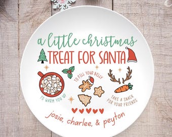 May include: White ceramic Christmas plate with the text "a little christmas TREAT FOR SANTA". The plate features illustrations of a Christmas tree, hot cocoa, gingerbread men, and carrots. The names "josie, charlee, & peyton" are also printed on the plate.