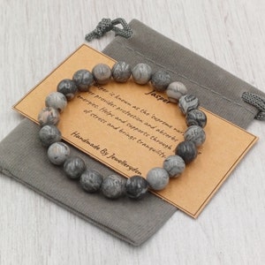 May include: Gray jasper stone bracelet with a brown card that reads "Jasper is known as the 'supreme nurturer' It provides protection and absorbs energies. Helps and supports through times of stress and brings tranquility. Handmade by Jewelleryden."