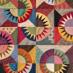 May include: A colorful quilt with a patchwork design featuring a repeating pattern of sunbursts in various colors and fabrics.