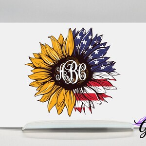 May include: A yellow sunflower with a red, white, and blue American flag design in the center. The sunflower has a monogram in the center of the flag.
