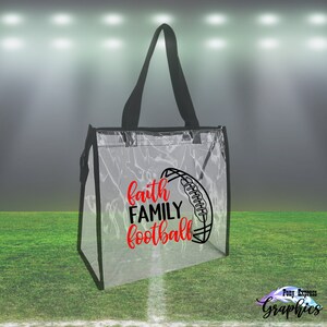 May include: Clear plastic tote bag with black handles and a black trim. The bag has a red and black design that says "faith family football" with a football graphic.