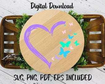 May include: A purple heart with a brushstroke effect is surrounded by a scattering of colorful butterflies on a wooden round sign. The sign is in a wooden basket with green foliage.