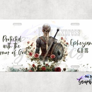 May include: White license plate featuring a watercolor illustration of a warrior with a sword and shield, surrounded by roses. Text reads "Protected with the Armor of God" and "Ephesians 6:11-18". The Pony Express Graphics logo is at the bottom.