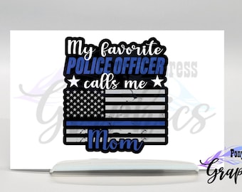 May include: A distressed American flag with a blue line running horizontally across the middle. The text "My favorite police officer calls me Mom" is above the flag. The flag is on a white background.
