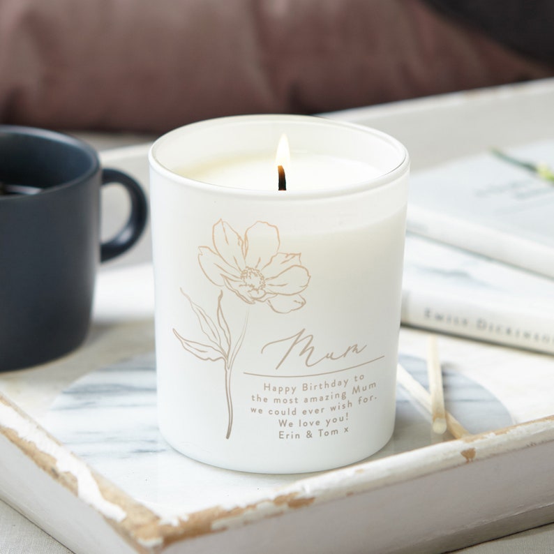 May include: White frosted glass candle with a floral design and the text "Mum Happy Birthday to the most amazing Mum we could ever wish for. We love you! Erin & Tom x".