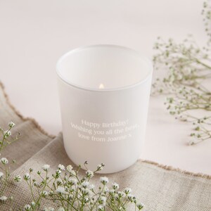 May include: White candle in a glass jar with a personalized message that reads "Happy Birthday! Wishing you all the best, love from Joanne x".