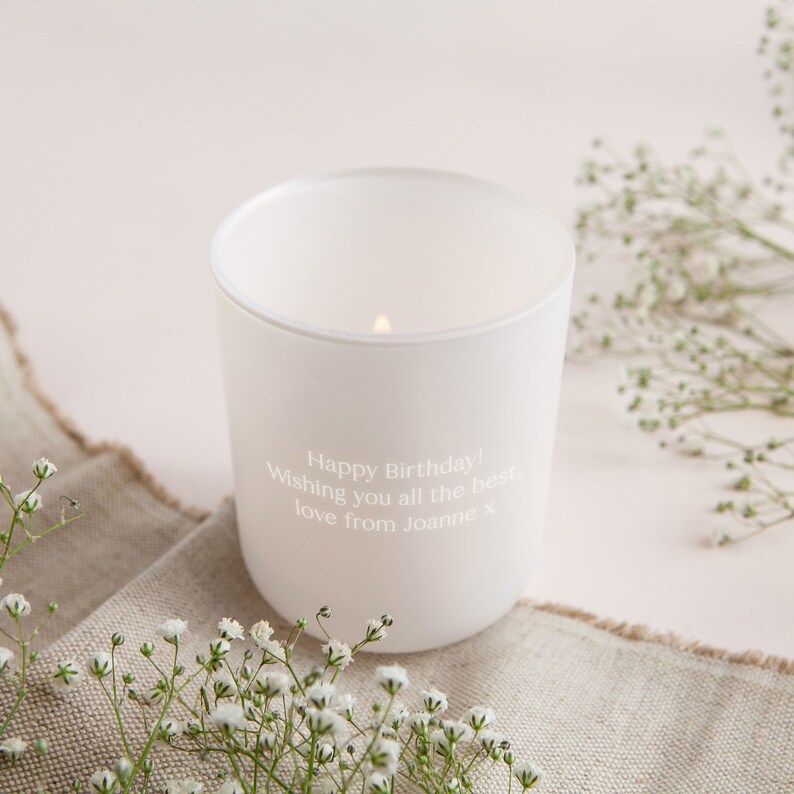 May include: White candle in a glass jar with a personalized message that reads "Happy Birthday! Wishing you all the best, love from Joanne x".
