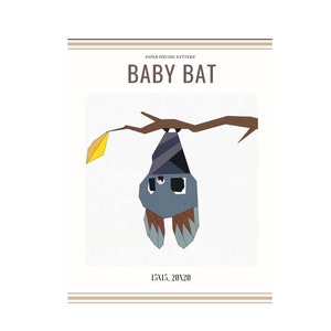 Può includere: Modello di patchwork per un pipistrello bambino, con un pipistrello grigio, marrone e blu appeso a un ramo con una foglia gialla. Il modello misura 15 pollici per 15 pollici e 20 pollici per 20 pollici.