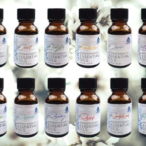May include: Twelve amber glass bottles with black caps, each containing 0.5 fl oz (14.8 ml) of essential oil. The bottles are labeled with the names of the oils, including Lavender, Eucalyptus, Tea Tree, Rosemary, and more.  The bottles are arranged in two rows of six, on a white background with white flowers.