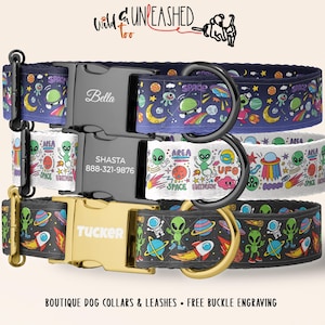 May include: Three dog collars with space-themed patterns featuring aliens, planets, and rockets. The top collar has a black buckle engraved with Bella, the middle has a black buckle with Shasta and 888-321-9876, and the bottom has a gold buckle with Tucker.