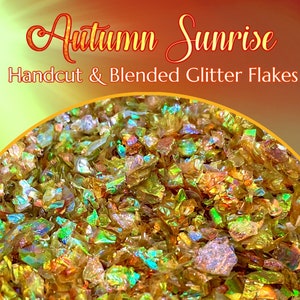 May include: Handcut and blended iridescent glitter flakes in shades of gold, green, and orange. The glitter is called "Autumn Sunrise".