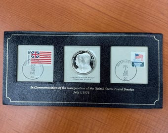 Conmemoración de la inauguración del Servicio Postal de los Estados Unidos en 1971. Moneda de plata y 2 sellos.