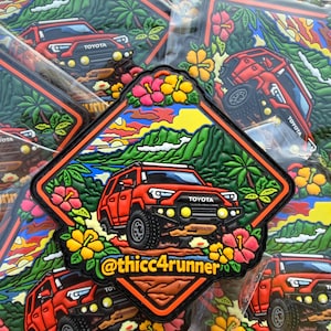 May include: A collection of colorful, die-cut stickers featuring a red Toyota SUV driving through a tropical landscape. The stickers have a black border and include the text "@thicc4runner" and the Toyota logo. The design incorporates flowers and palm trees.