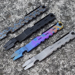 Puede incluir: Cuatro herramientas de palanca de metal multicolores con diferentes patrones y acabados. Las herramientas tienen un abridor de botellas y una palanca.