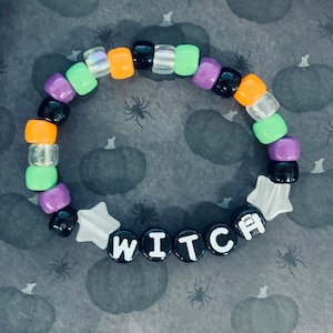 May include: A colorful beaded bracelet with a star charm and the word "WITCH" spelled out in black beads.