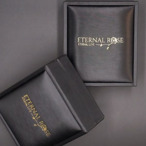 Pode incluir: Duas caixas pretas com o texto "Eternal Rose" e "Eternal Love" em letras douradas. As caixas s&atilde;o feitas de um material texturizado e t&ecirc;m um design elegante e moderno.