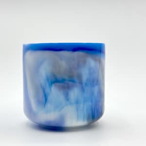 May include: A blue and white swirl resin cup with a smooth, glossy finish.