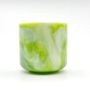 Peut inclure: Un gobelet cylindrique avec une base arrondie. La tasse présente un motif marbré de couleurs vertes et blanches tourbillonnantes. Le bord supérieur est vert vif uni. La tasse est faite d'un matériau solide.