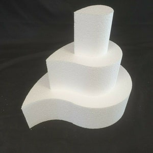 May include: Three white polystyrene cake dummies shaped like teardrops, stacked on top of each other. The top dummy is the smallest and the bottom dummy is the largest.