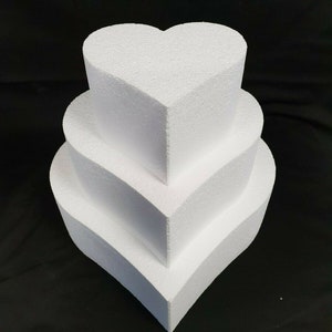 May include: Three white heart-shaped foam cake dummies stacked on top of each other. The dummies are made of polystyrene and are used for cake decorating.