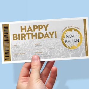May include: A rectangular birthday gift ticket featuring gold text that reads HAPPY BIRTHDAY and a gold scratch-off circle with the text NOAH KAHAN. The ticket includes fields for date 30/10/26, venue WEMBLEY, ticket holder GEORGIA, and a message.