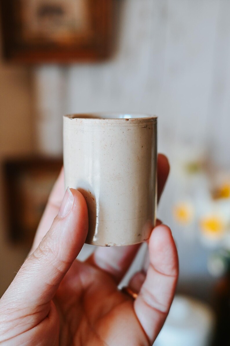 May include: A set of three ceramic mugs with a speckled, matte finish. The mugs are in shades of cream, light gray, and dark gray. Each mug has a simple, minimalist design and a rounded handle.