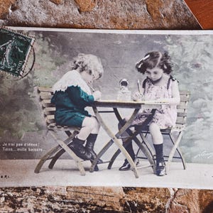 Postal francesa antigua: Niños adorables escribiendo cartas - Arte coleccionable efímero nostálgico