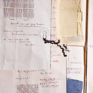 Pode incluir: Documento antigo com anotações manuscritas, diagramas e amostras de tecido. As páginas incluem texto em francês, marcas de tinta vermelha e azul e um pequeno pedaço de tecido amarelo claro. A data "4 JUIL 1932" é visível.