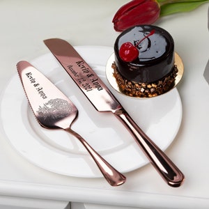 May include: Rose gold cake server and knife set with engraved text "Kevin & Anna" and "Kevin & Anna December 12, 2021". The set is on a white plate with a small chocolate cake with a cherry on top.