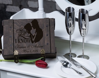 Può includere: Una scatola di legno con un coperchio incernierato, incisa con la silhouette di una coppia e il testo "I hope you I KNOW", "Faina & Adam" e "May 3, 2024". Due flute da champagne e un coltello da torta sono anche incisi con la silhouette di una coppia.