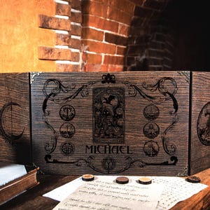 May include: A wooden three-panel folding game board with an engraved design. The center panel features a tarot card image and the name "MICHAEL".