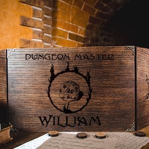 Könnte beinhalten: Ein hölzerner Dungeon Master-Bildschirm mit einem schwarz-weißen Design eines 20-seitigen Würfels in einem Flammenkreis. Der Bildschirm ist mit dem Text "Dungeon Master" und "William" graviert.