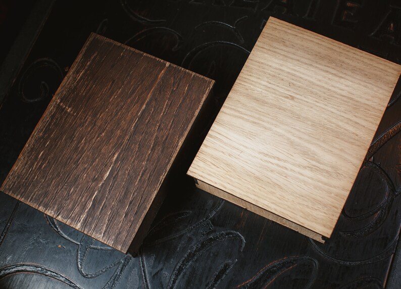 Puede incluir: Dos cajas de madera, una es de color marr&oacute;n oscuro y la otra es de color marr&oacute;n claro. Ambas cajas tienen un patr&oacute;n de veta de madera.