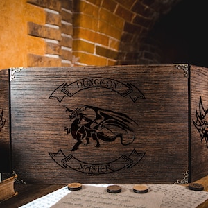 May include: A dark wooden Dungeon Master screen featuring a dragon emblem and the text "DUNGEON MASTER". The screen has metal corner protectors. Several wooden tokens are placed in front of the screen.