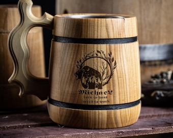 May include: A wooden beer stein with a black band and a laser engraved design of a bear in a forest with the text "Michael born to hunt forced to work".