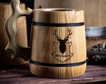 May include: A wooden beer stein with a stainless steel interior. The stein has a black band around the top and bottom and a deer head design with the name "Michael" engraved on the front.