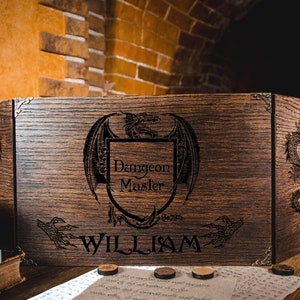 May include: A dark wooden Dungeon Master screen featuring a dragon crest and the text "Dungeon Master" and "William". The screen has dragon engravings and is set on a wooden table. The screen is made of dark wood.