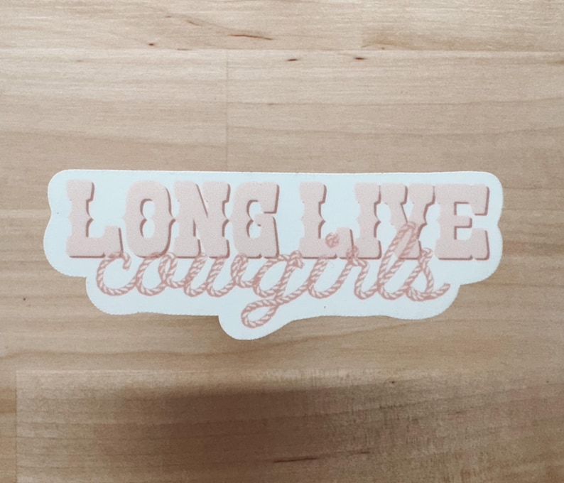 May include: White sticker with the text "LONG LIVE cowgirls" in pink lettering with a rope design around the words.