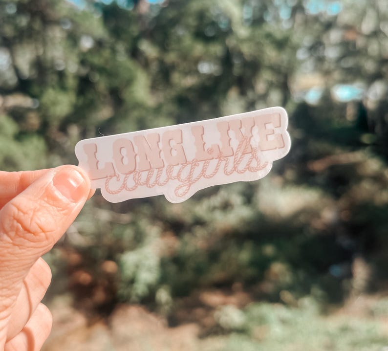 May include: A pink sticker with the text "Long Live Cowgirls" in a stylized font. The text is outlined with a rope design.
