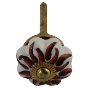 May include: White ceramic cabinet knob with a red and black floral design and a gold metal base.