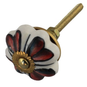 Può includere: Pomo per cassetti in ceramica bianca con un design floreale rosso e nero e una base in metallo dorato.