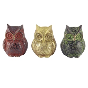 May include: Three decorative owl figurines, each with a different color: red, gold, and green. The owls have a detailed, patterned design and large, round eyes.