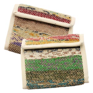 May include: Two colorful woven wallets with a white fabric border. The wallets are made from recycled materials and have a unique, handmade look.