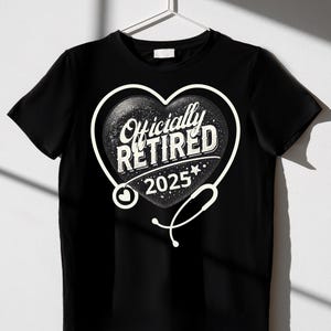 Puede incluir: Camiseta negra con un gráfico blanco de un corazón con un estetoscopio. El corazón tiene el texto "Officially Retired 2025" en su interior.