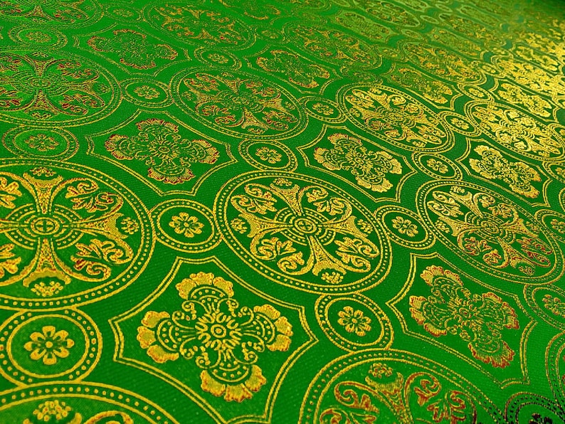 Puede incluir: Tela verde con un dise&ntilde;o estampado en dorado y rojo. El patr&oacute;n presenta c&iacute;rculos repetidos con una cruz en el centro.