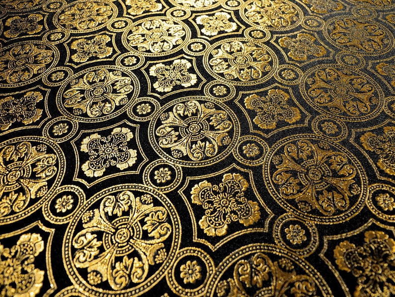 Puede incluir: Una tela negra con un patr&oacute;n repetitivo de c&iacute;rculos dorados y dise&ntilde;os florales.